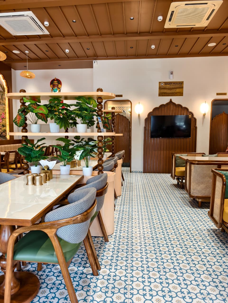 South Masala dining room with green seating, warm wood, and handcrafted architectural details