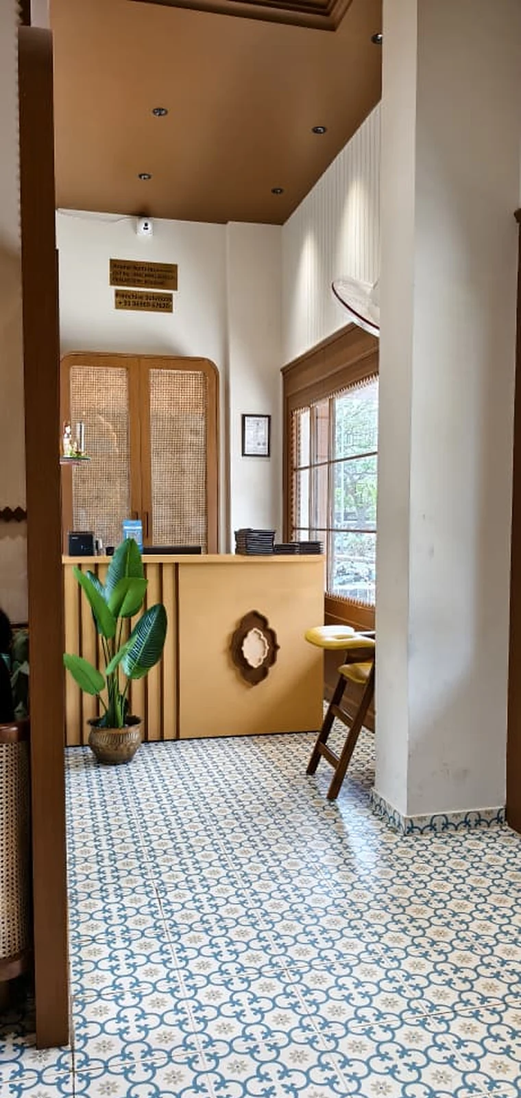 A quiet reception corner at South Masala with patterned floors and warm woodwork